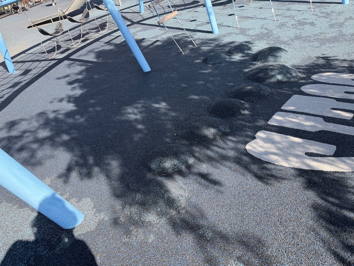 Raised blue moguls built into the rubber playground surface at Colts Canal Playground