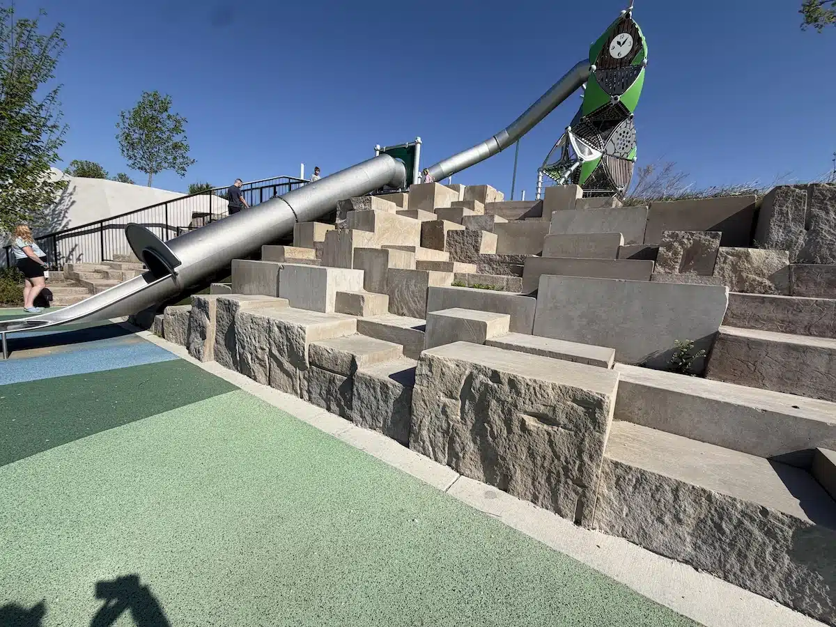 West Park in Carmel: A Year-Round Playground, Splash Pad and Sledding Destination 5 Stepped stone block climbing feature and tube slide at West Park playground in Carmel
