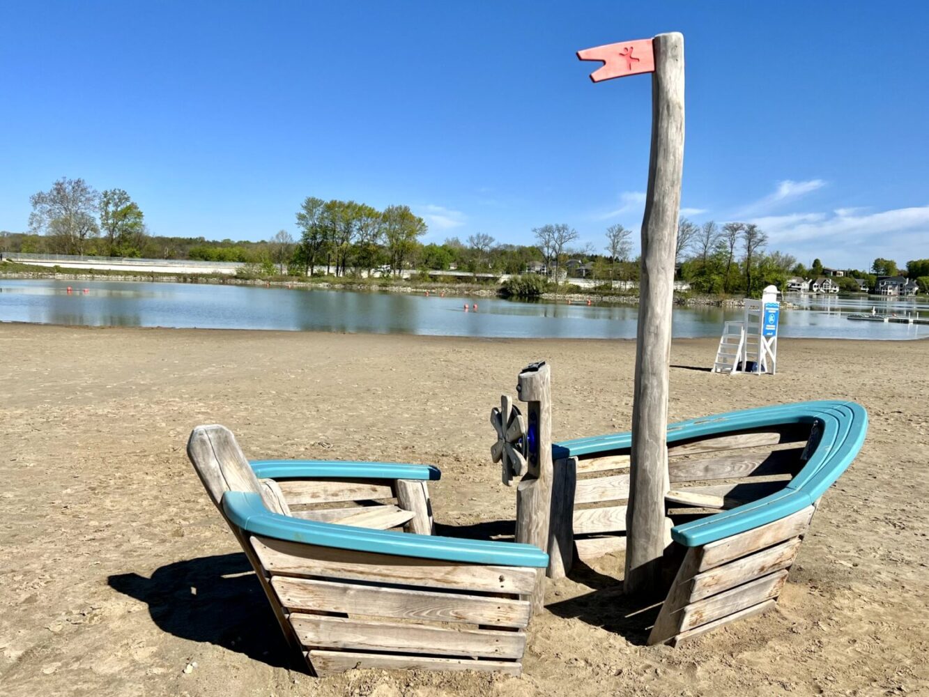 Top 15 Things to Do in Fishers with Kids (2025) 2 Families on sandy swim beach and pirate-ship playground at Geist Waterfront Park, Fishers