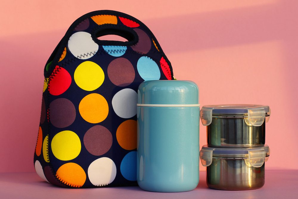 snack on a break with a lunchbox. colorful handbag, blue thermos and two metal containers with food. lunch for a schoolboy or an office worker