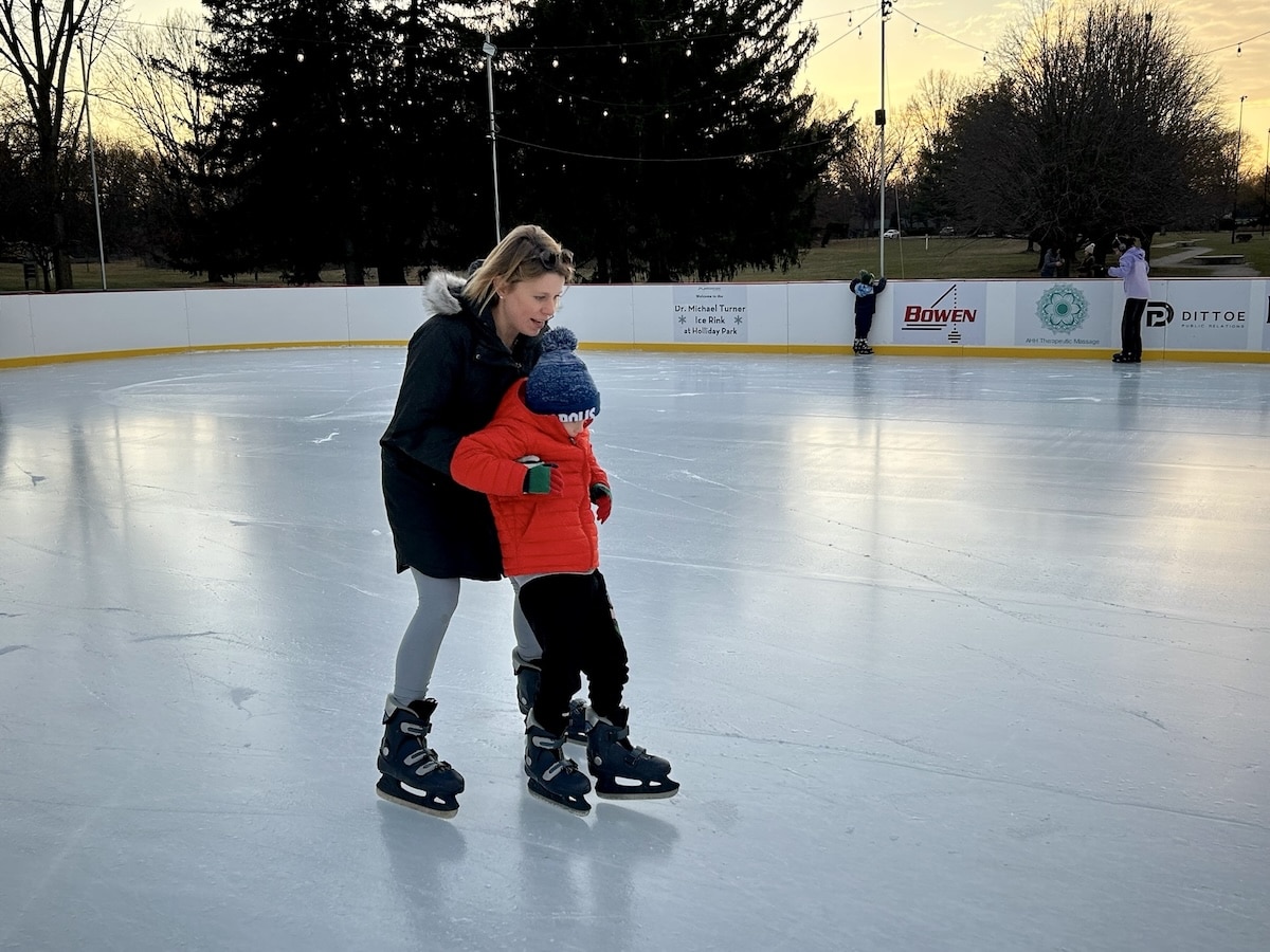 Mother skating with son at Holliday Park Ice Rink in Indianapolis during outdoor family ice skating