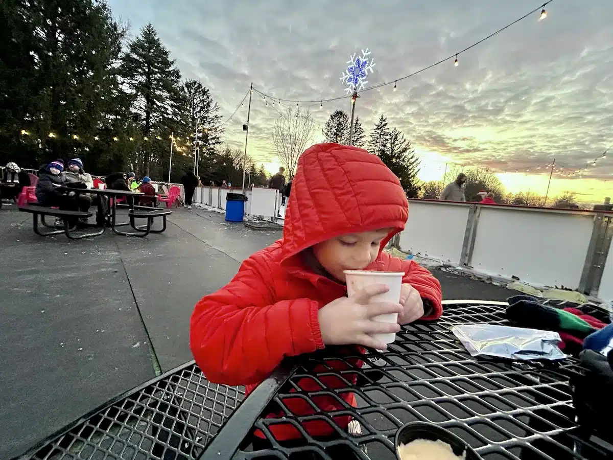 Kids drinking hot chocolate at Holliday Park Ice Rink in Indianapolis after an afternoon family skate