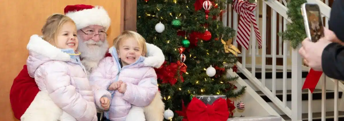 Two children sitting on Santa’s lap at Brownsburg’s Christmas Under the Stars