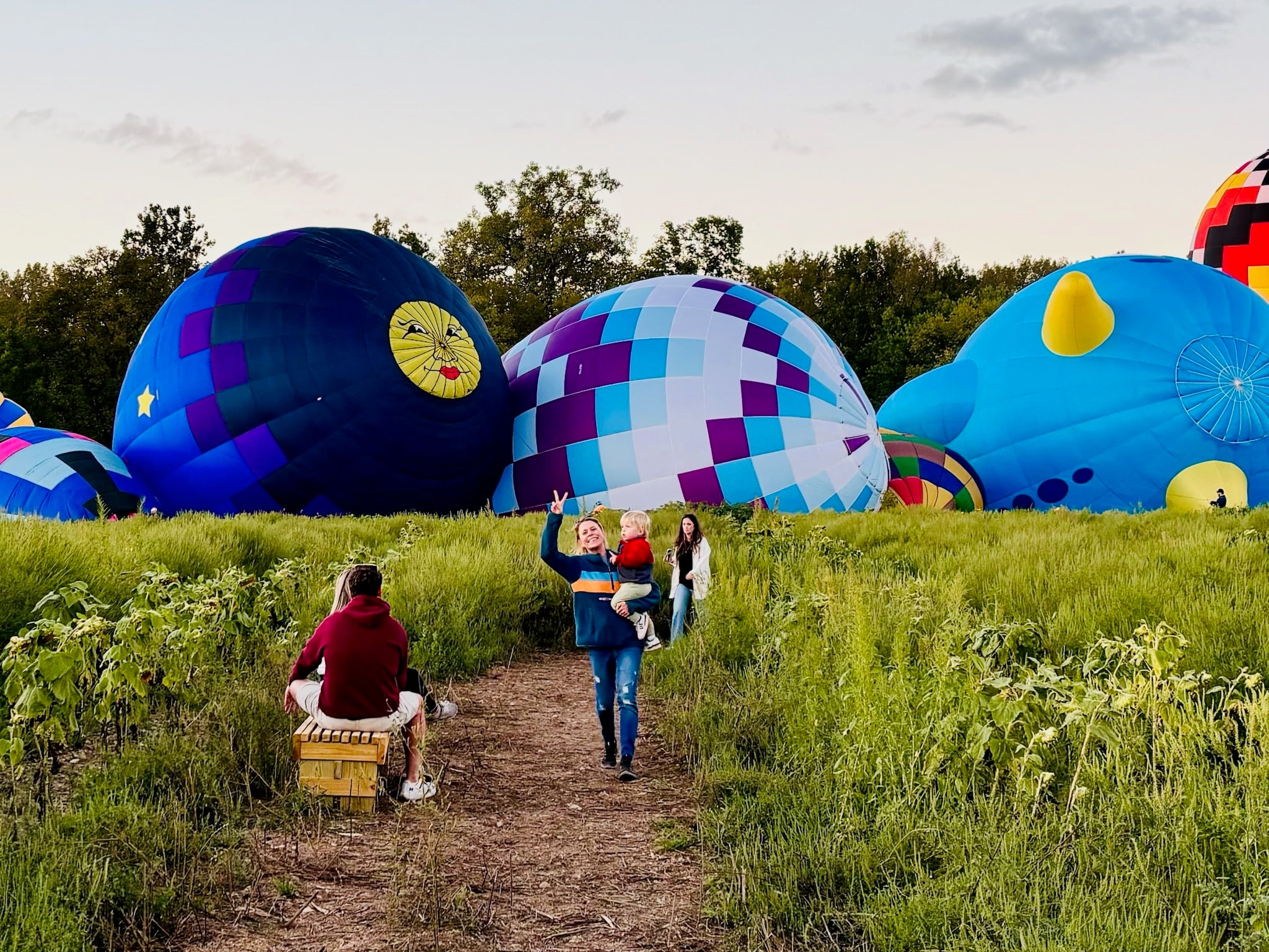Jupiter Flights Balloon Festival Returns to Conner Prairie 2026 5 Glowing hot air balloons near the sunflower field at Conner Prairie