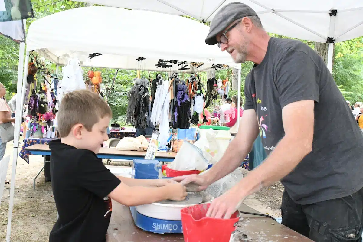 Child works with clay in the kids area at the Penrod Arts Fair