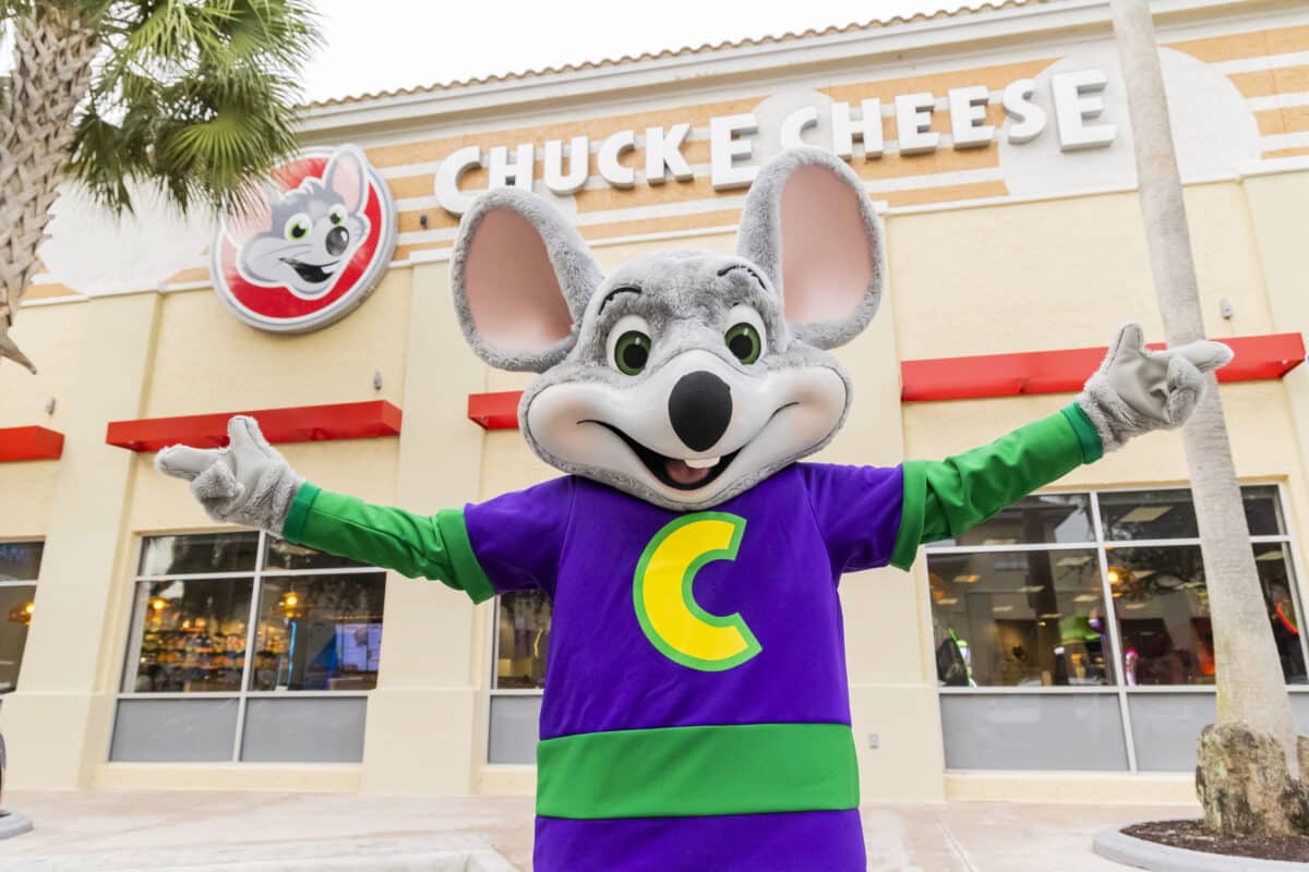 The Chuck E. Cheese mascot outside a Chuck E. Cheese restaurant