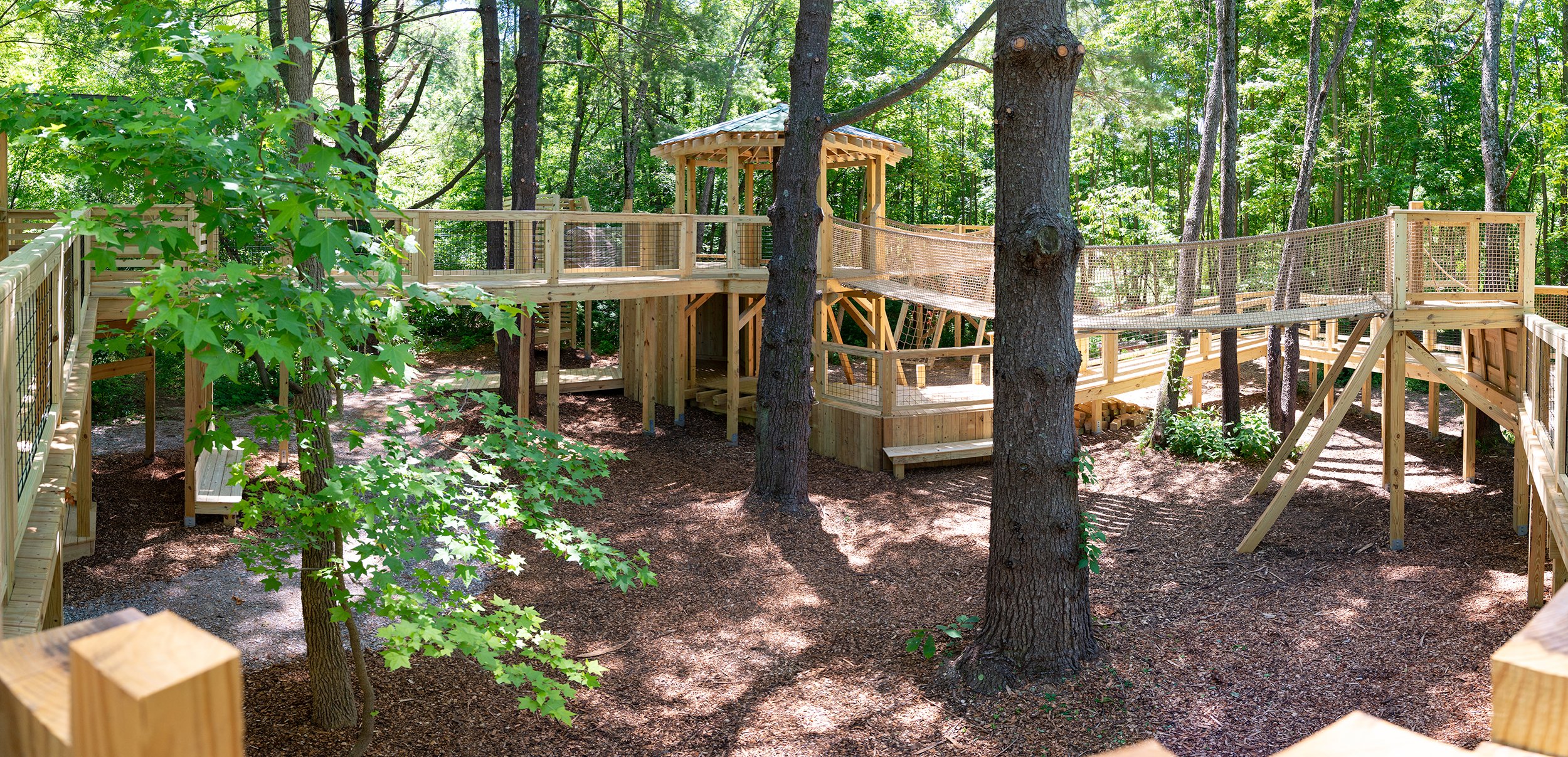 children climbing treehouse and exploring natural play area at Wesselman Woods Nature Playscape in Evansville Indiana