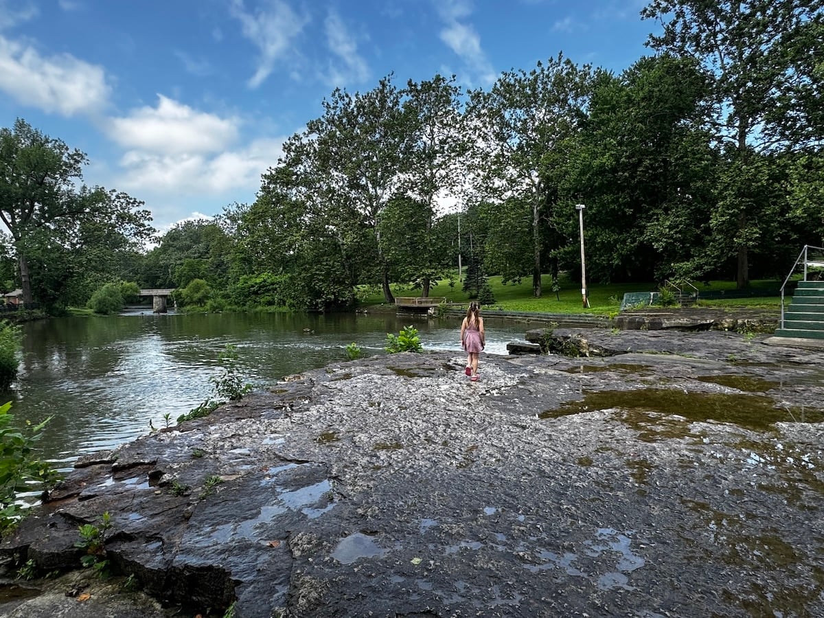 girl standing on top of the Falls Park in Pendleton Waterfall creek stomping
