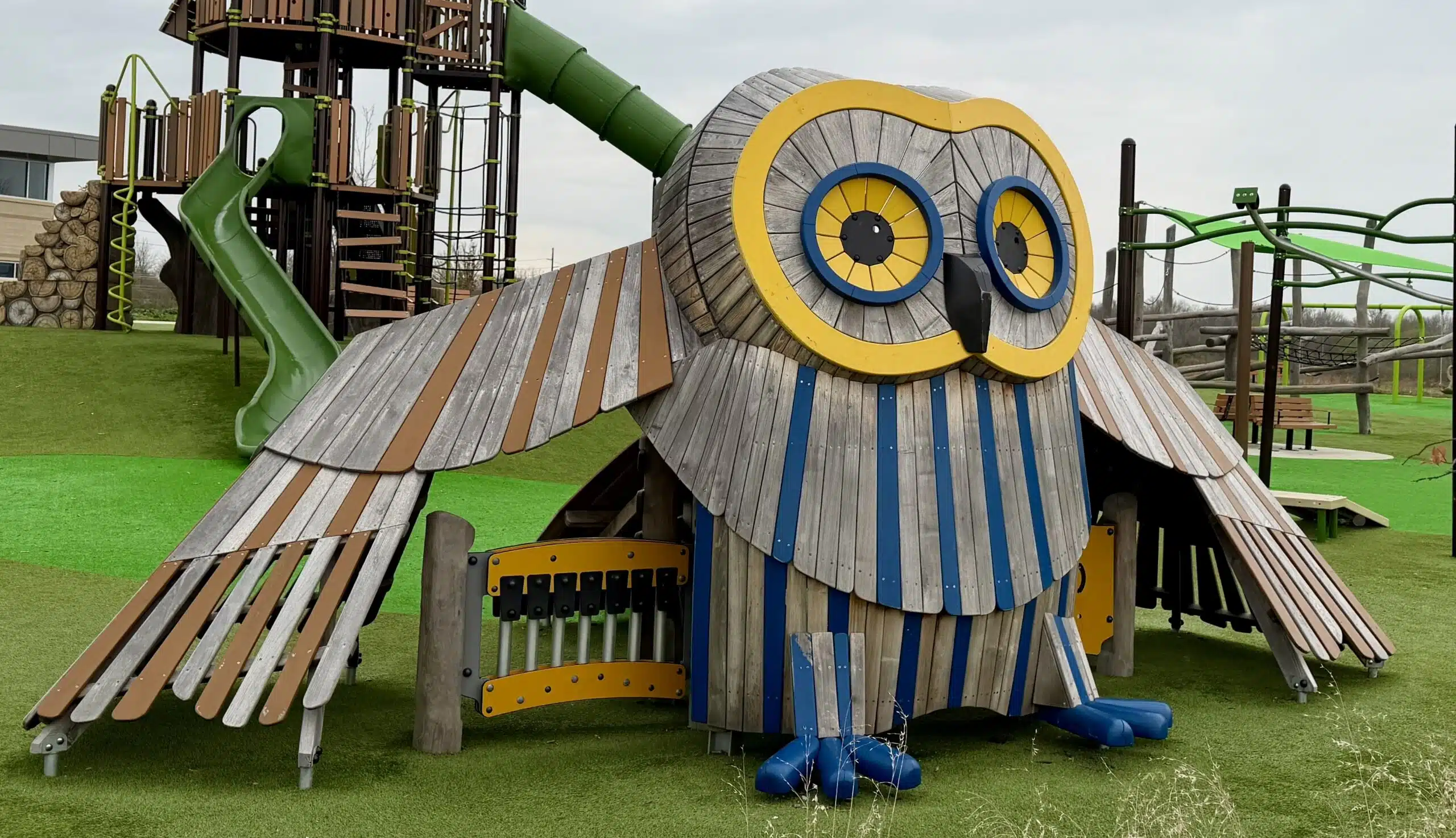 Giant wooden owl play structure with climbing features, slide and xylophone at Grassy Creek Park playground in Indianapolis