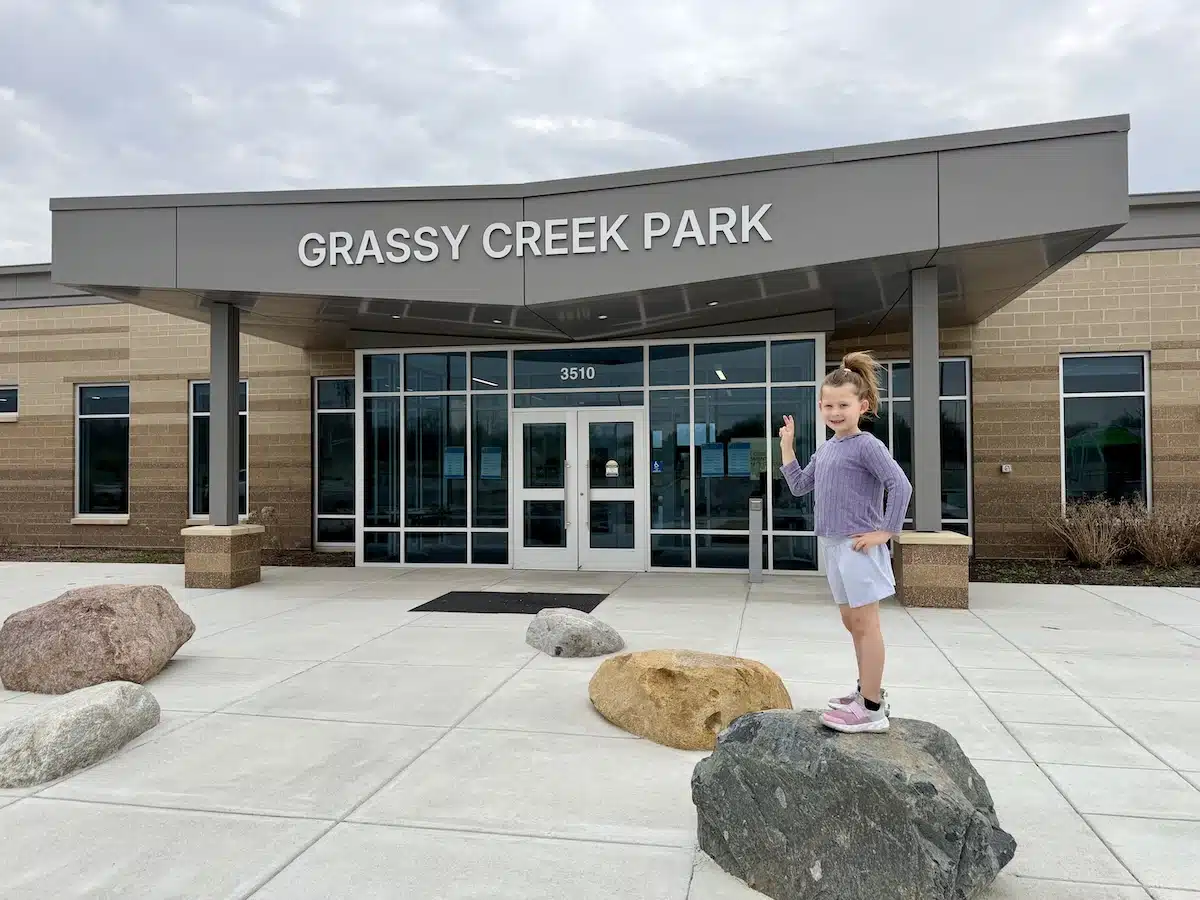 Young girl standing on landscape rocks outside the Grassy Creek Environmental Community Center in Indianapolis