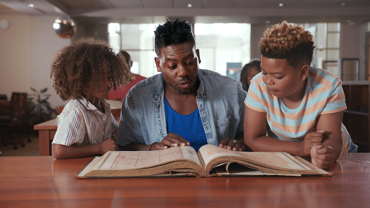 emmanuel and kids looking at book 1 1