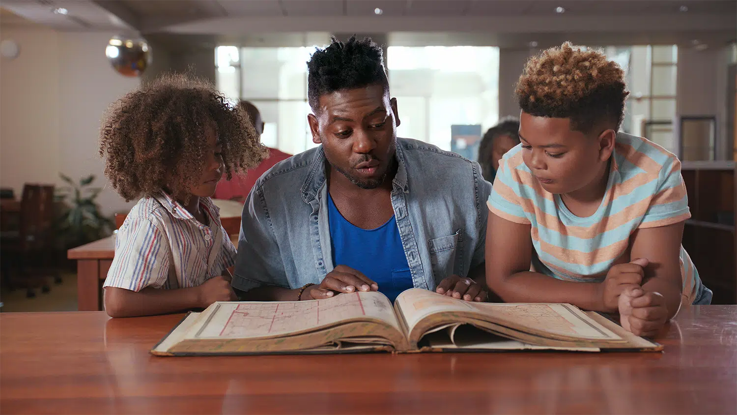 emmanuel and kids looking at book 1 1