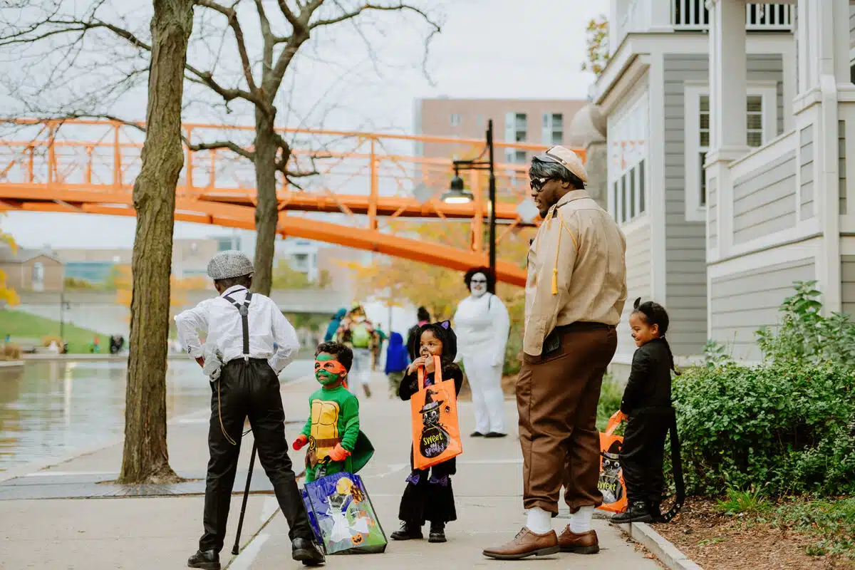 Families in Halloween costumes trick-or-treating along the Downtown Canal