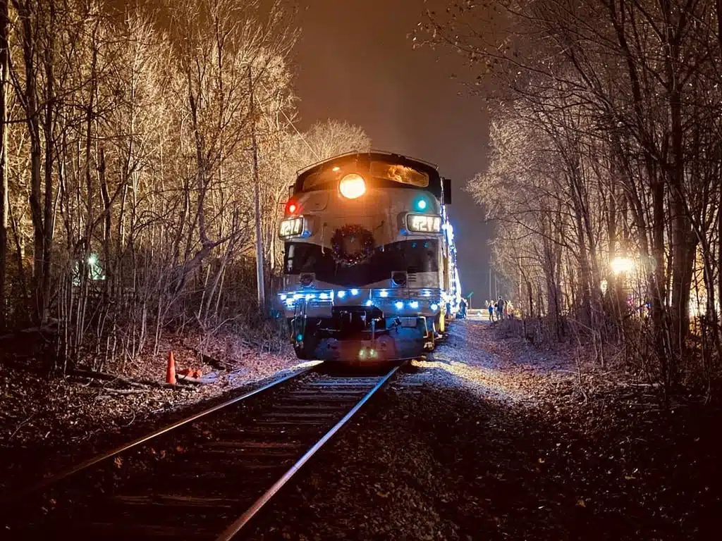 Holiday-lit locomotive on the tracks at night for the Reindeer Express train ride in Noblesville
