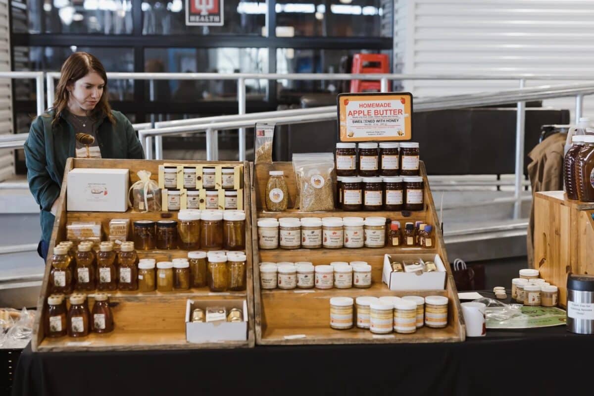 A vendor table of local honey and apple butter at the Indy Winter Farmers Market at The AMP