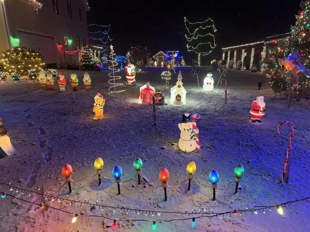 Light-up holiday figures and giant bulbs in the snow at Christmas Acres