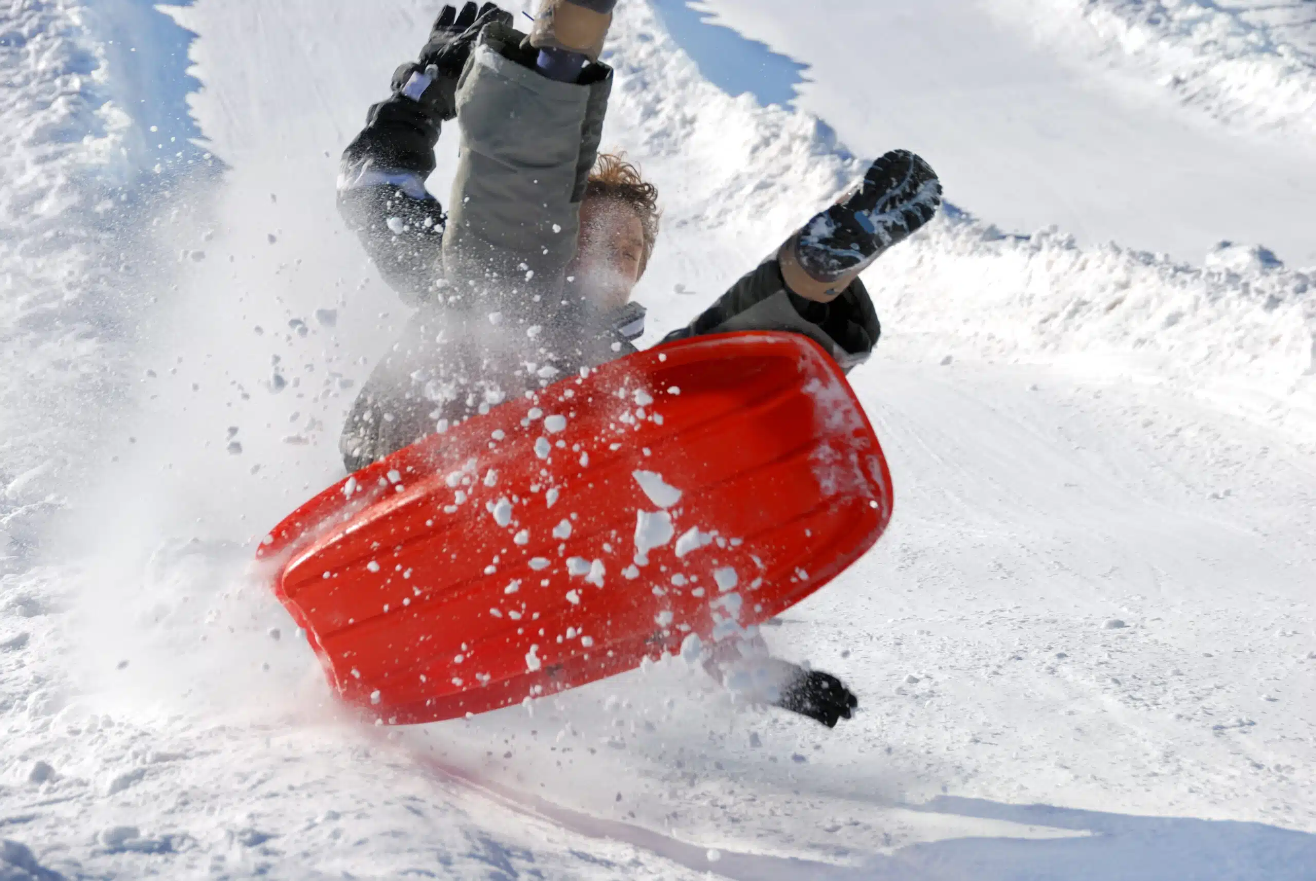 Boy airborne on sled flying down steep sledding hill in Indianapolis area