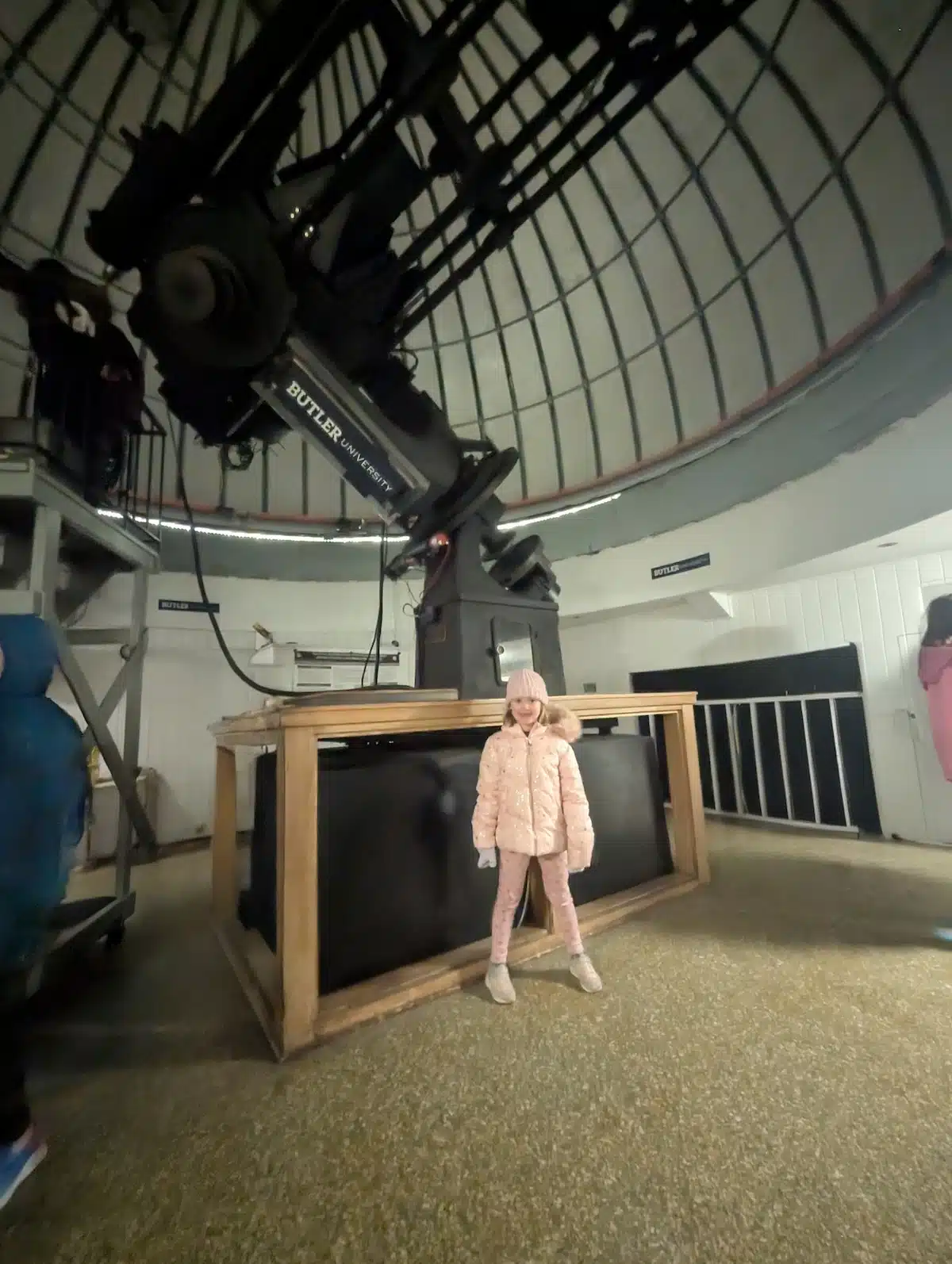 Child standing near Indiana’s largest telescope inside the open dome at Holcomb Observatory, Butler University