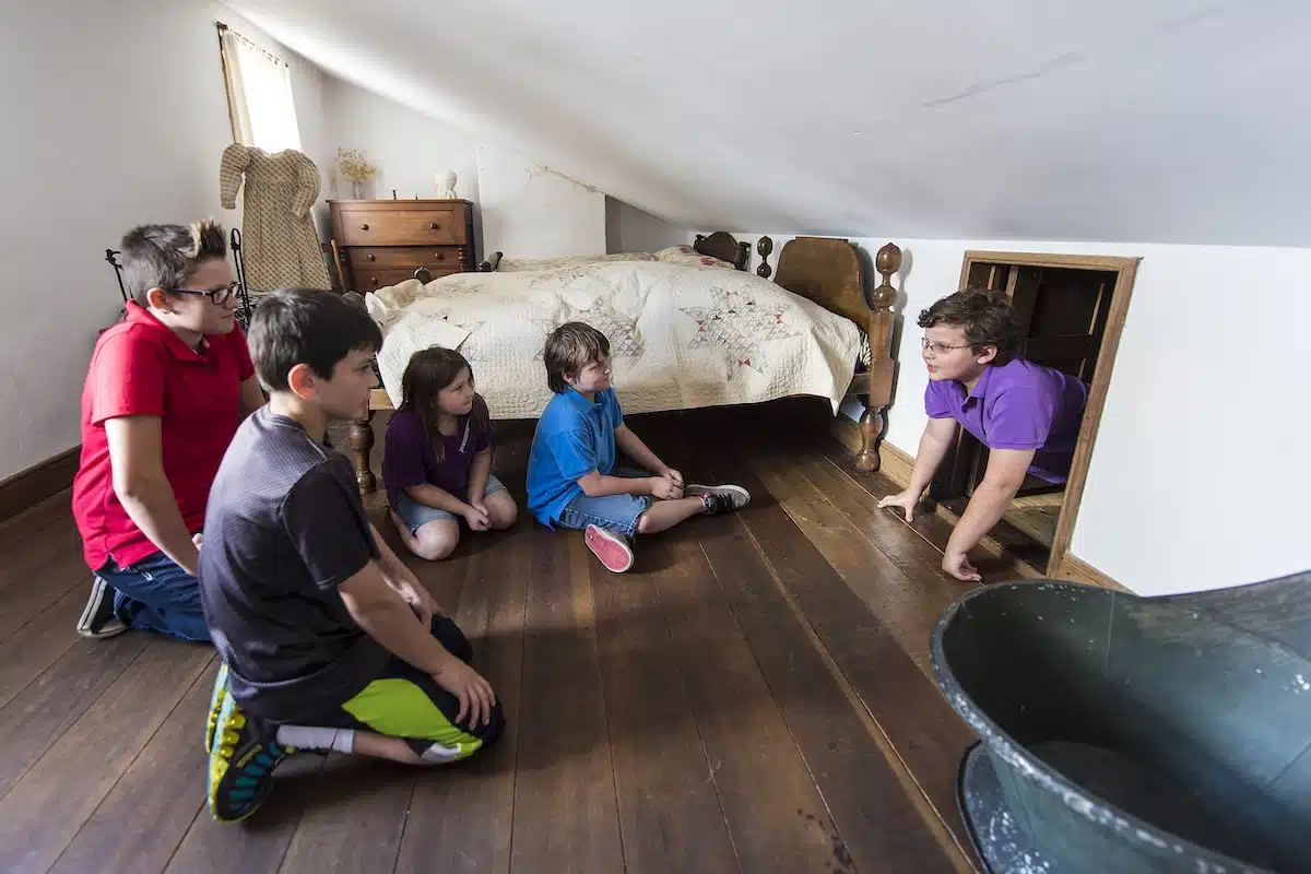 Kids peeking into the historic hiding place at the Levi and Catharine Coffin State Historic Site
