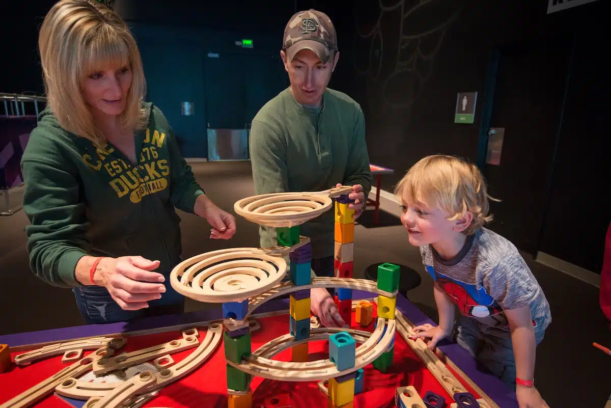 Child playing a marble maze tabletop puzzle in the Mazes & Brain Games exhibit at the Indiana State Museum