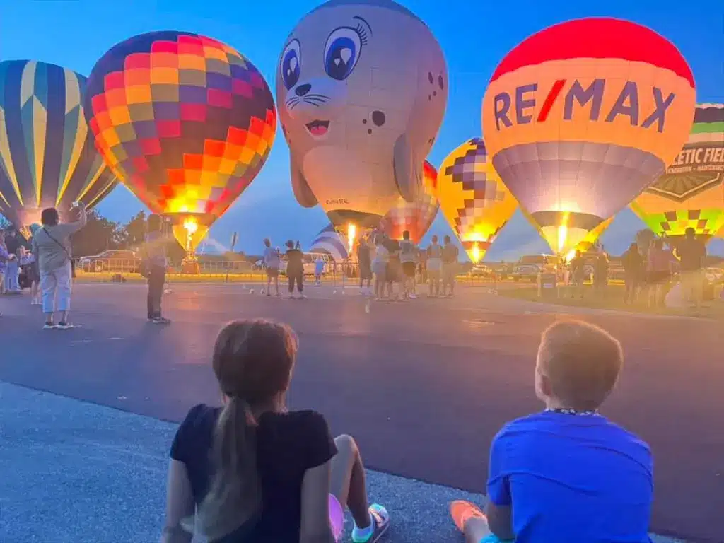 Families watching a hot air balloon glow at Angola Balloons Aloft
