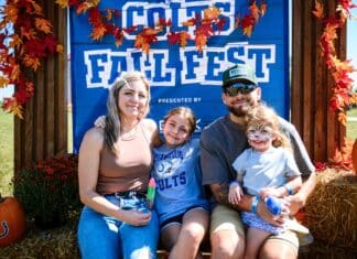 Fall Fun with the Colts Family posing in front of a Colts Fall Fest banner decorated with fall leaves