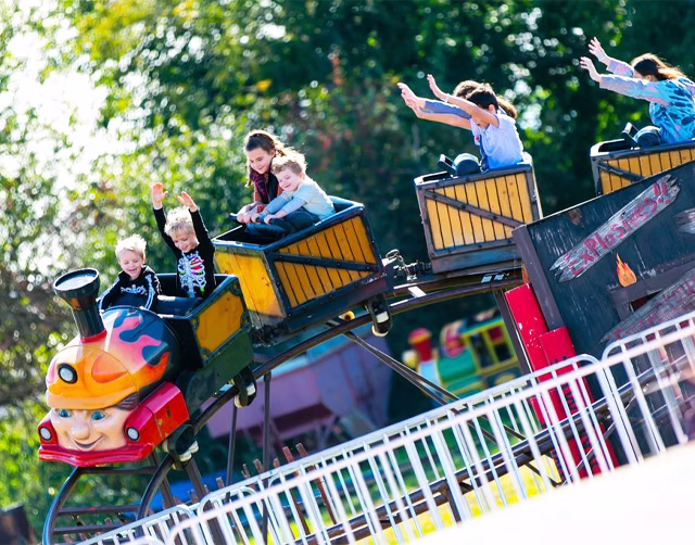 Children riding a colorful amusement ride at Harvest Tyme