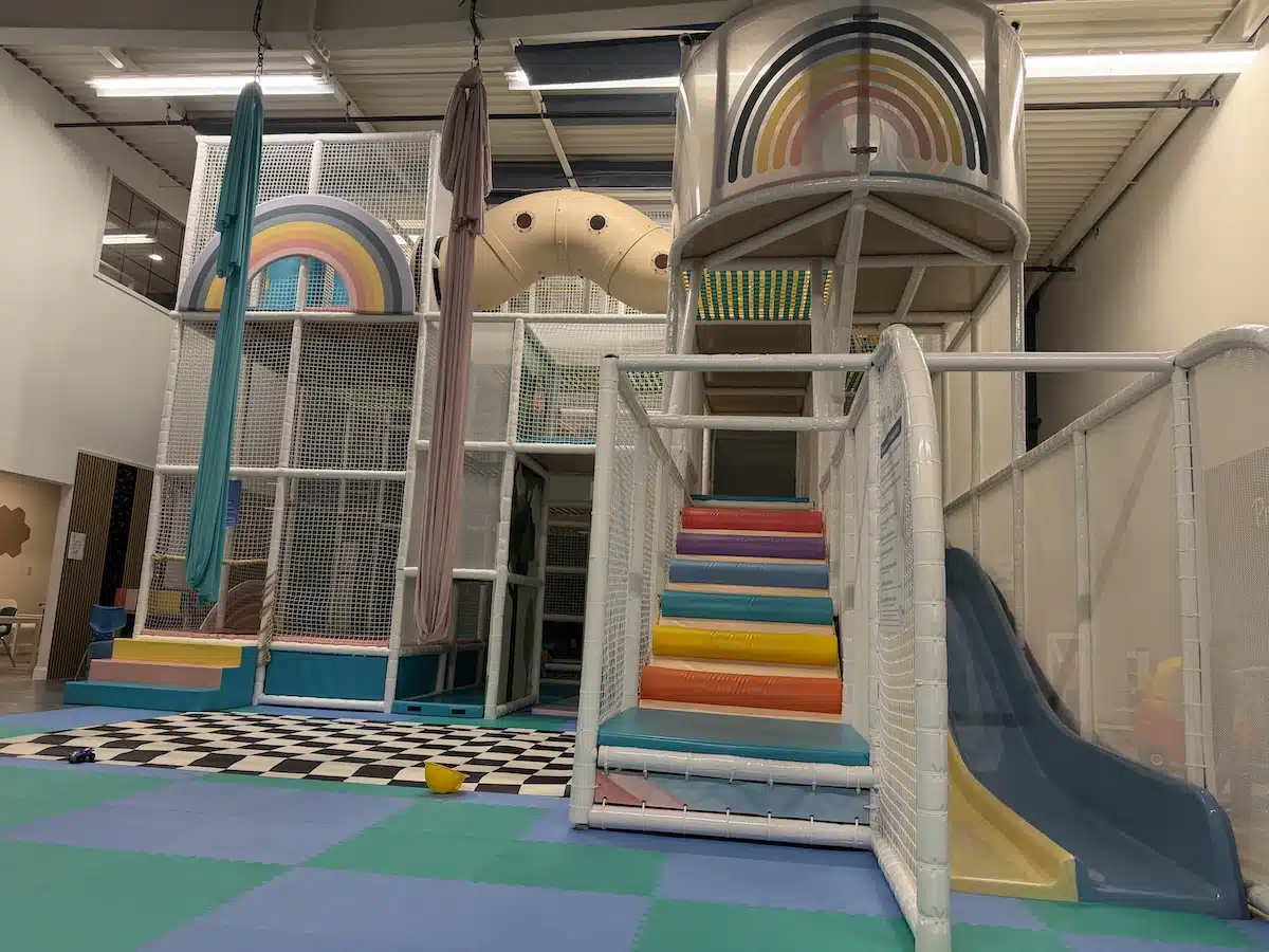 Inside Prana Play, a Sensory-Friendly Play Space in Carmel 3 Rainbow stairs, enclosed tunnels and slide in the indoor playground at Prana Play in Carmel