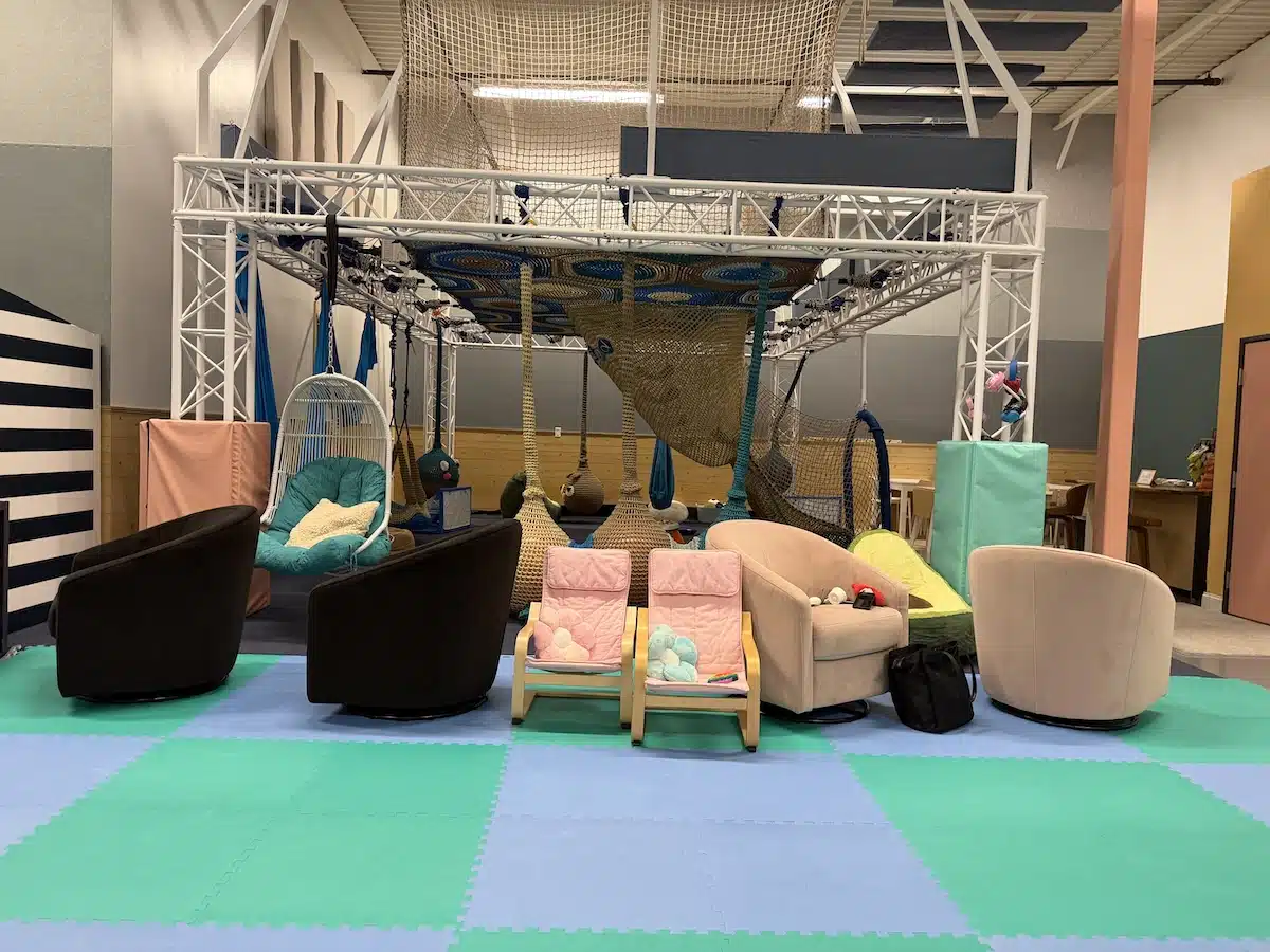 Inside Prana Play, a Sensory-Friendly Play Space in Carmel 4 Comfortable parent seating beside the climbing net at Prana Play
