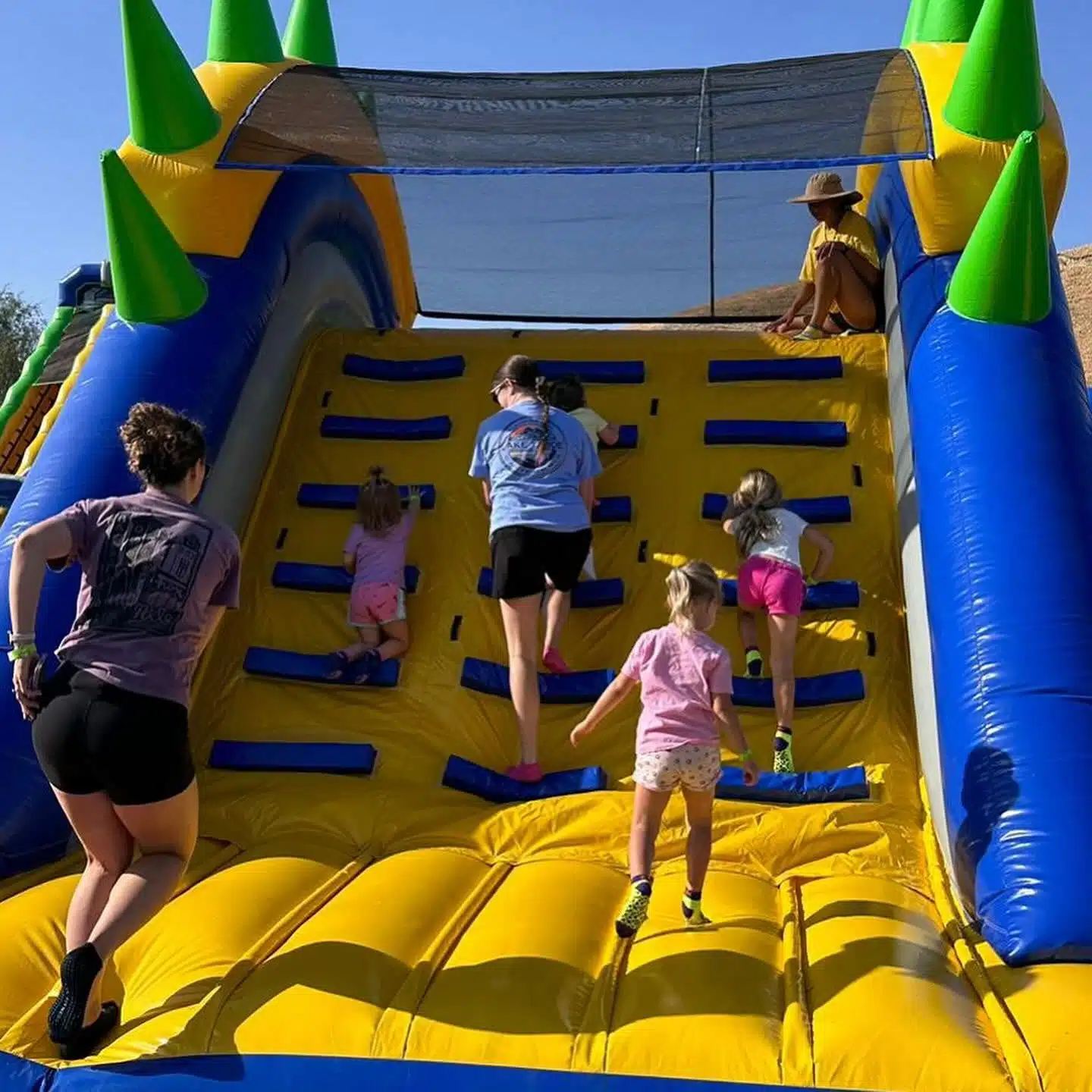 Giant 1,000-Foot Inflatable Obstacle Course Coming to Zionsville 1 Kids climbing a yellow, green and blue inflatable obstacle on the Tuff Nutterz course