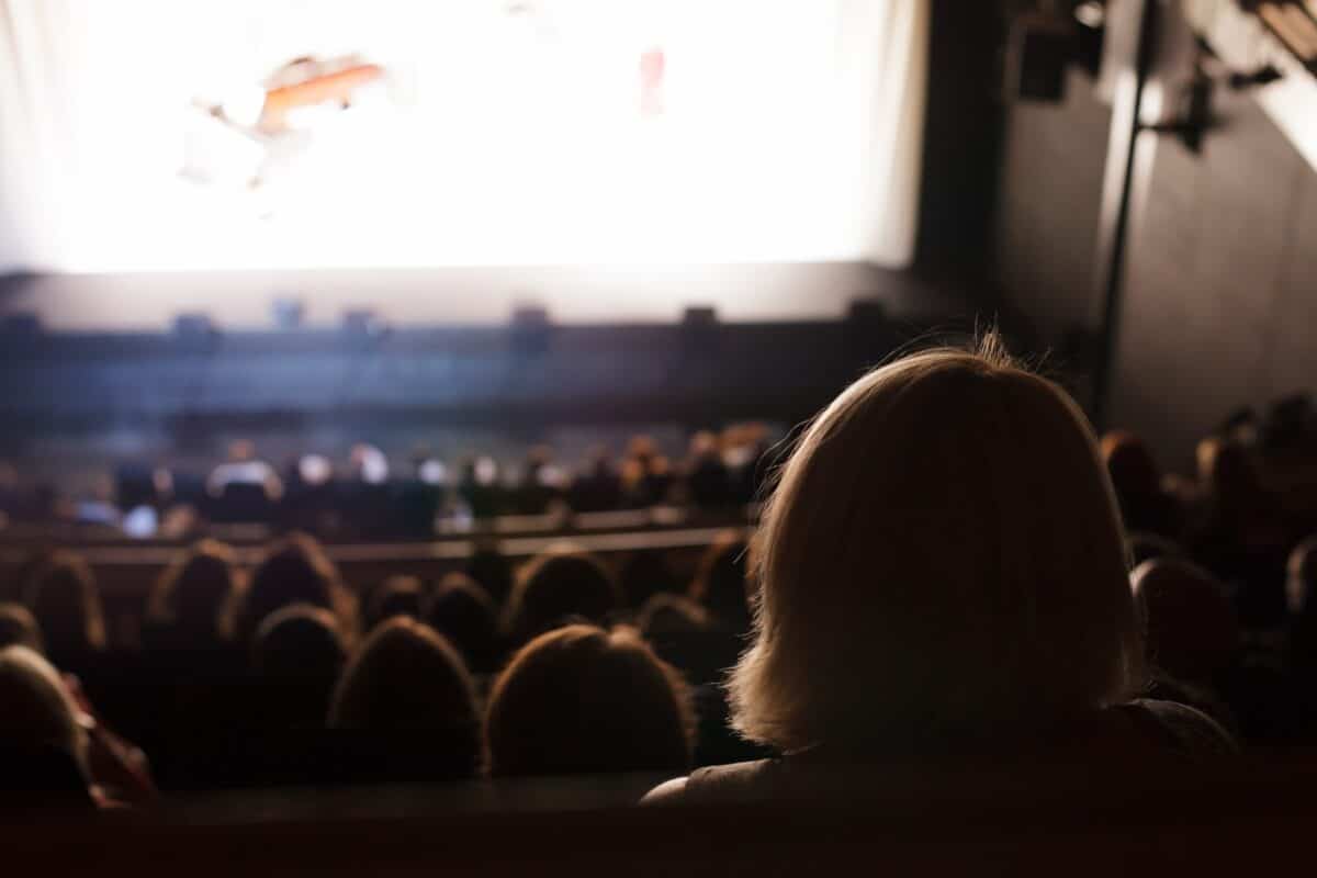 An audience in their seats facing a lit stage