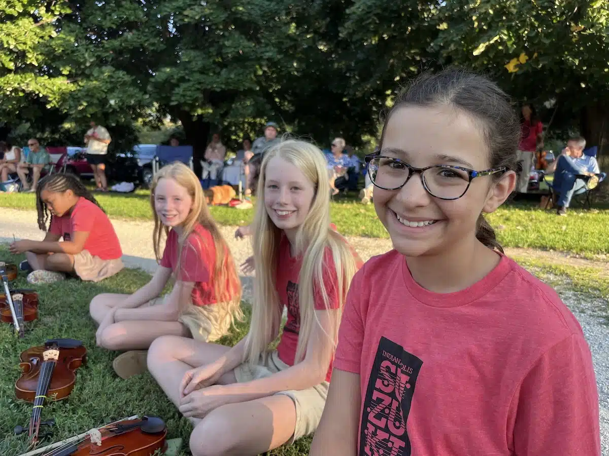 Children and families participating in an Indianapolis Suzuki Academy activity outdoors
