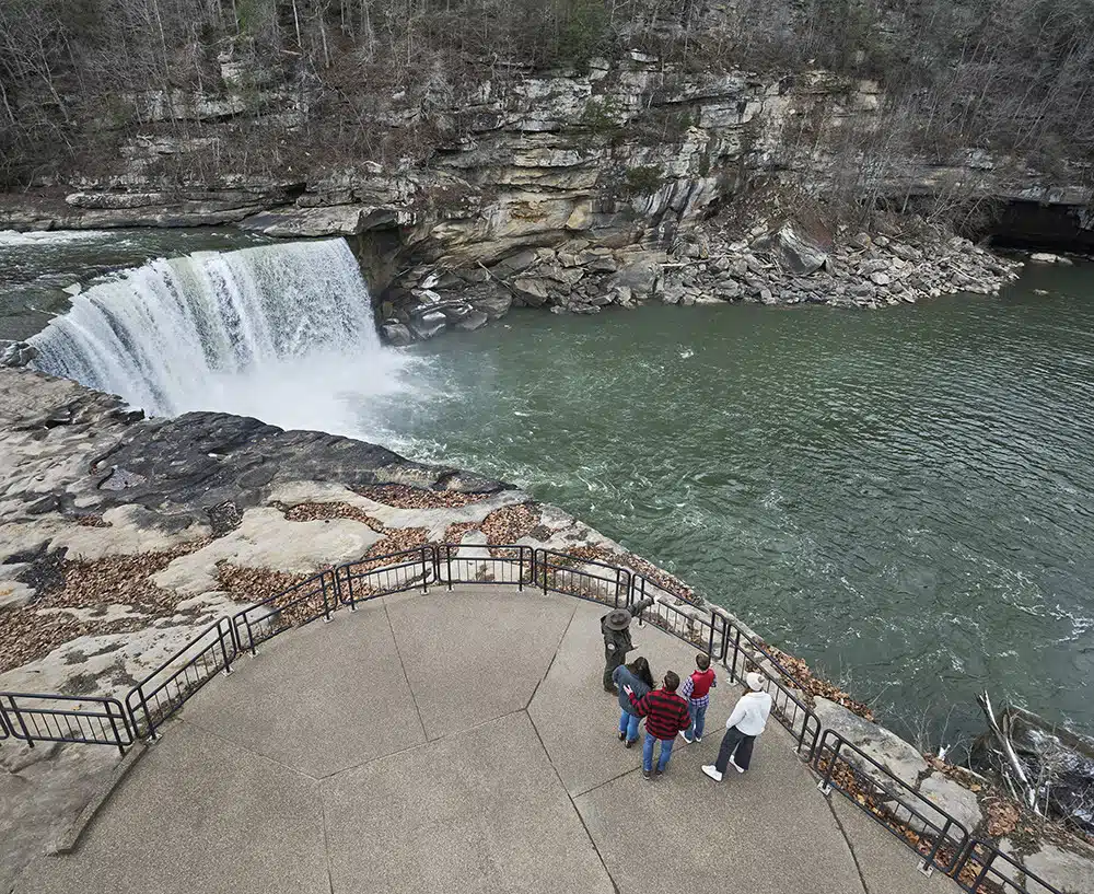 Cumberland Falls Moonbow: What It Is and Why It's Worth the Drive 3 A park ranger and visitors at the railed overlook above Cumberland Falls, with the green Cumberland River below