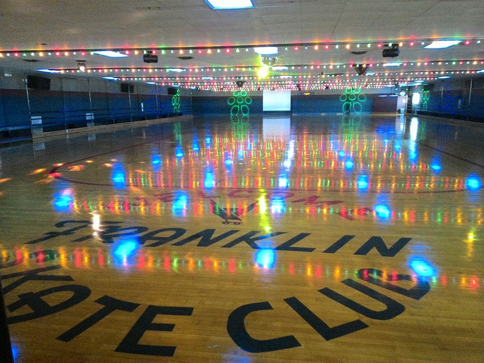 The roller skating floor at Franklin Skate Club with colored lights overhead