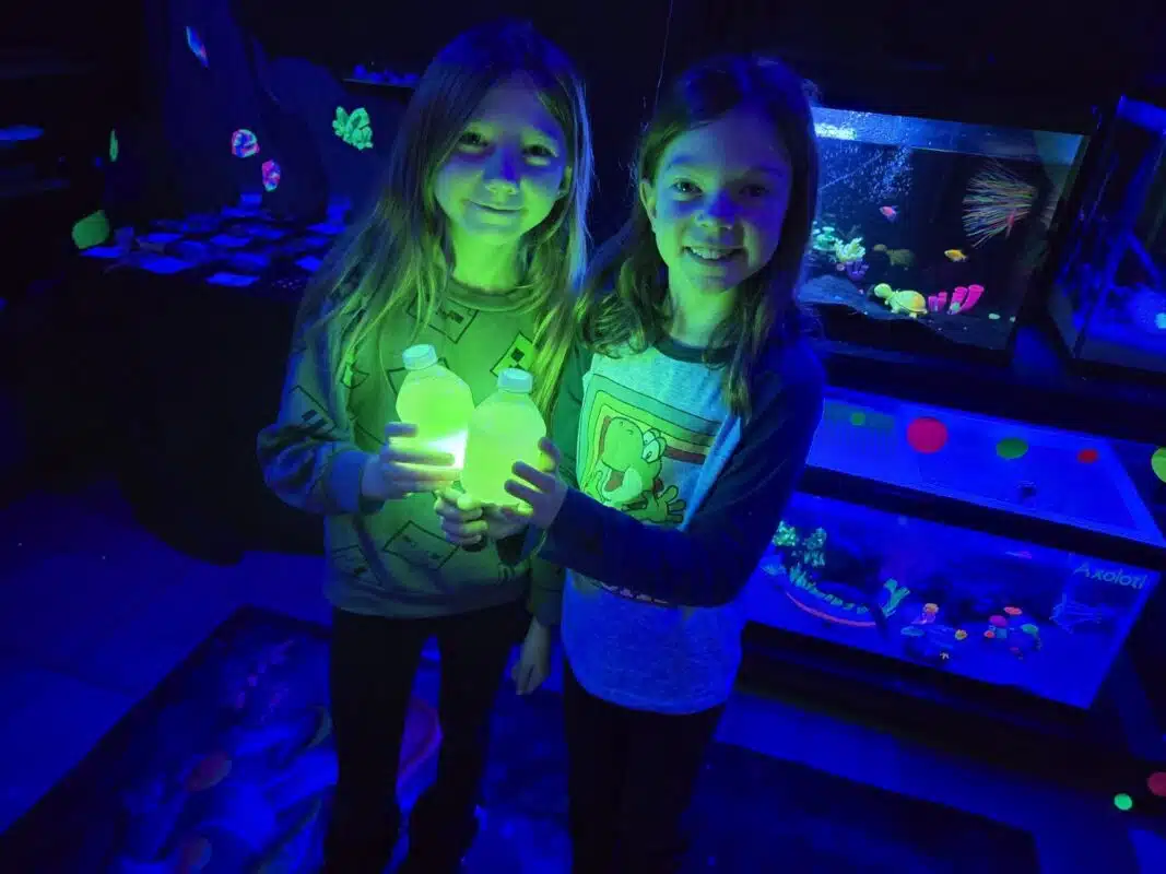 Two girls holding glowing jars during a Washington Township Parks homeschool program