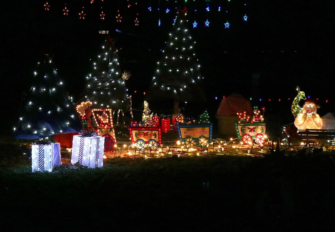 A campsite decorated with lighted Christmas trees and holiday displays at Nights of Lights in Mounds State Park