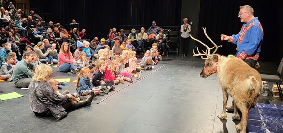 A Silly Safaris presenter shows a reindeer to children seated on the floor