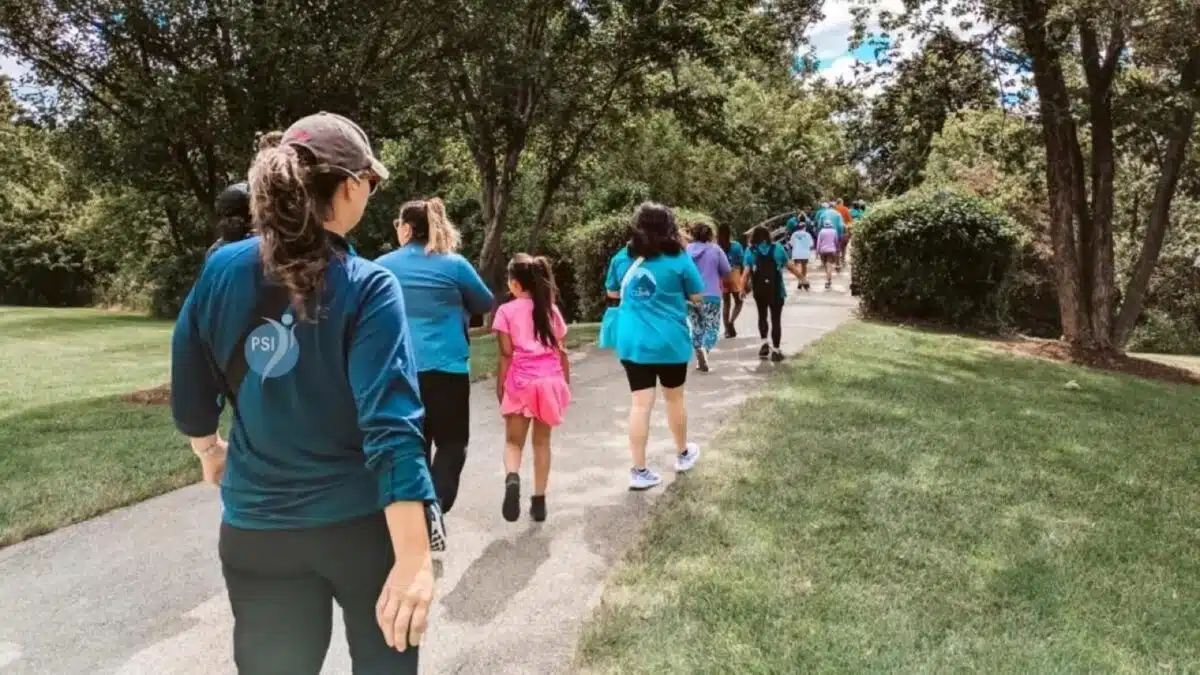 Families walking together on a park path at a Climb event