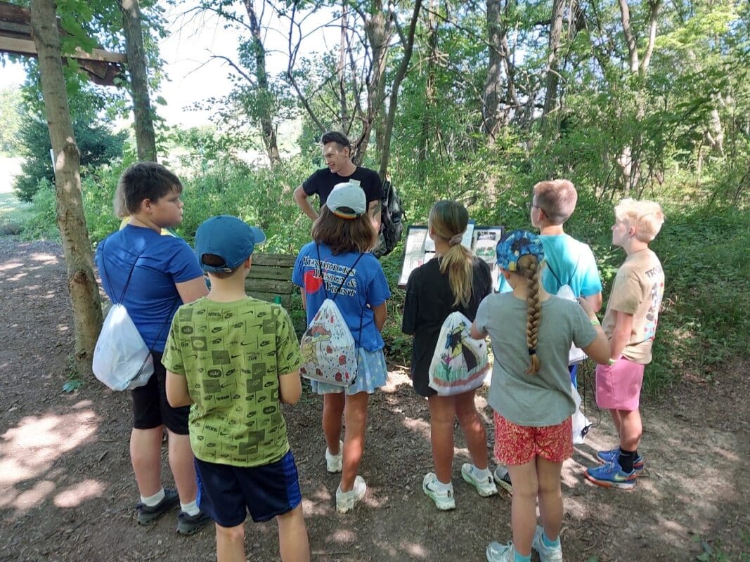 A Washington Township Parks naturalist teaching a group of students on a wooded trail