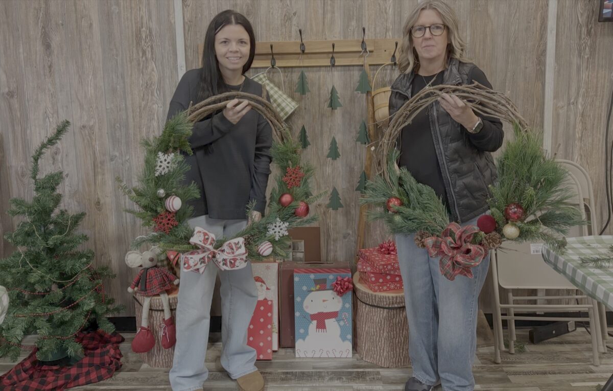 Two participants hold finished evergreen wreaths at McCloud Nature Park